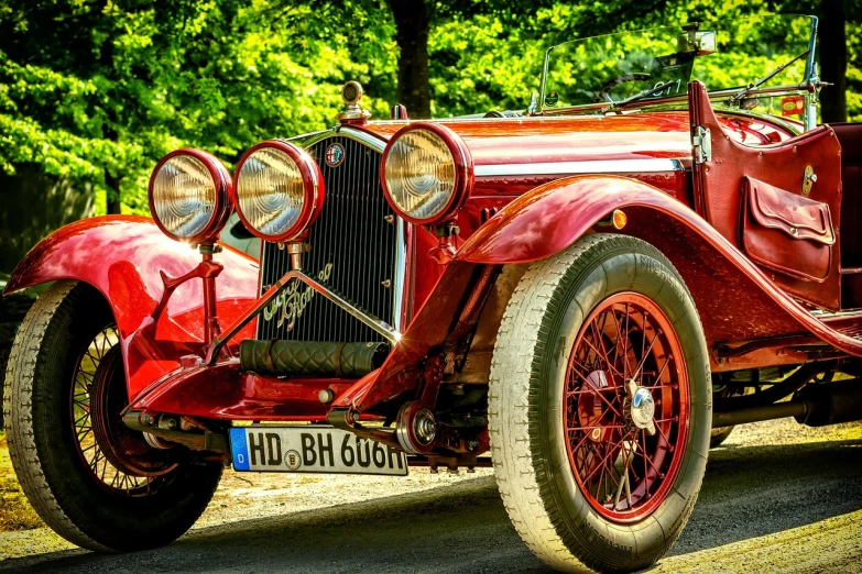 an old red car is parked on the side of the road, by Leo Goetz, trending on pixabay, art nouveau, full view of a sport car, tonemapped, roaring twenties, hot summer sun