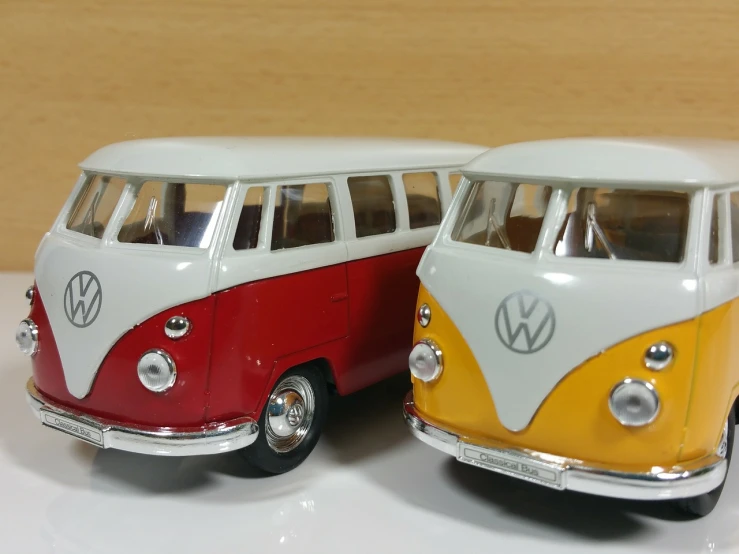 a couple of toy cars sitting next to each other, by Hiroyuki Tajima, flickr, photorealism, kombi, shot with iphone 1 0, red yellow, 3/4 front view