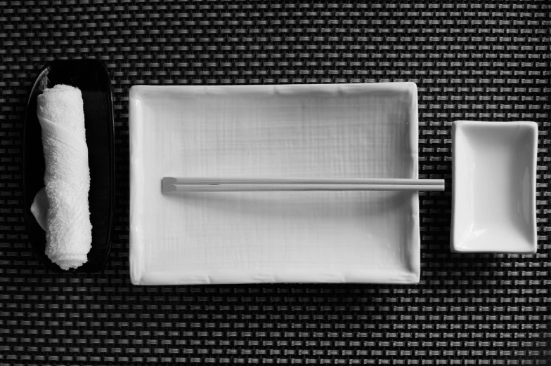 a black and white photo of a tray with chopsticks and a towel, minimalism, porcelain, very sharp photo