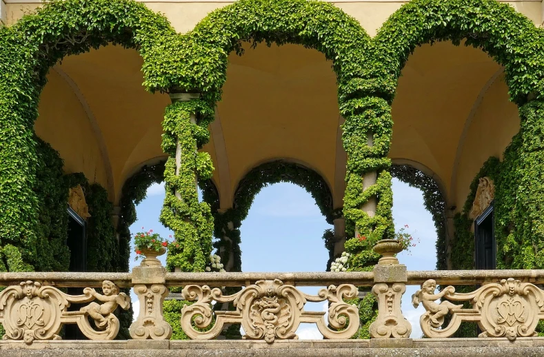 a building covered in lots of green plants, a picture, inspired by Mirabello Cavalori, pixabay, baroque, beautiful terrace, with archways, marterpiece, castelvania