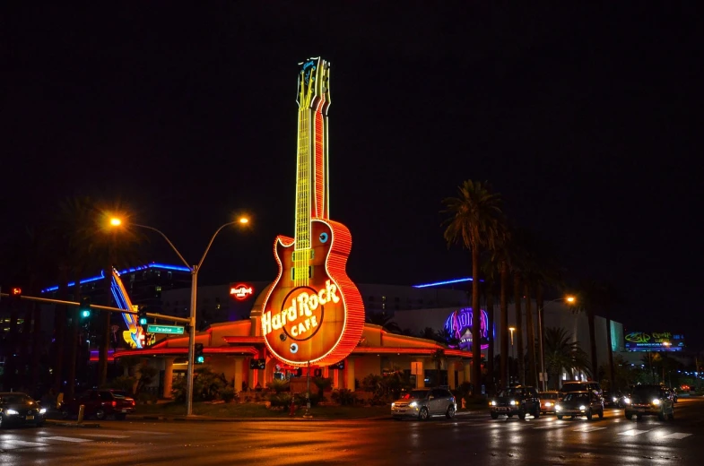 a neon guitar sign sitting on the side of a road, by Randy Post, shutterstock, indoor casino, that is 1300 feet tall, usa-sep 20, annie lebovetz