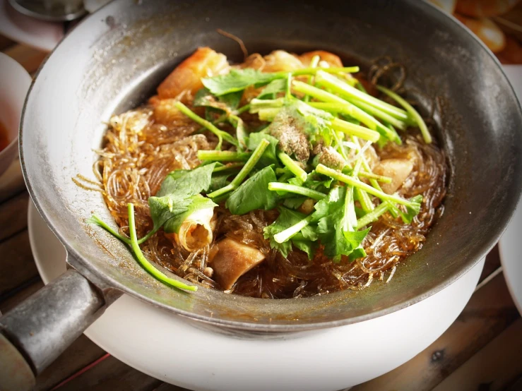 a pan filled with food sitting on top of a wooden table, inspired by Tan Ting-pho, dau-al-set, high detail product photo