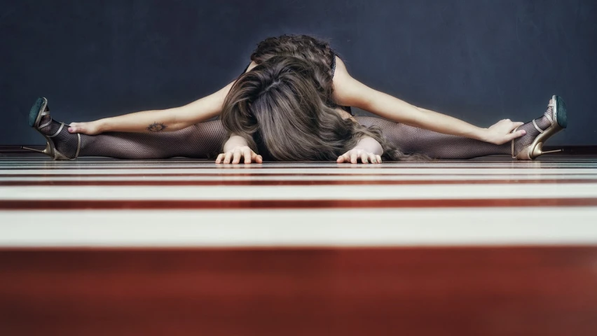 a woman sitting on top of a hard wood floor, by Elizabeth Polunin, unsplash, hyperrealism, white stripes all over its body, suspiria, symmetry composition, lying on an abstract