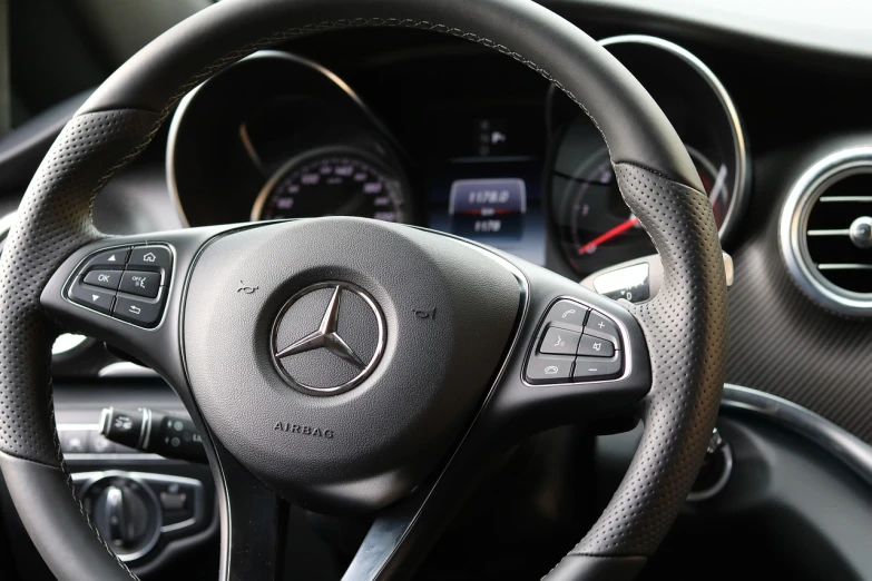 a close up of a steering wheel in a car, mercedez benz, autofocus, 2 0 % pearlescent detailing, stern expression