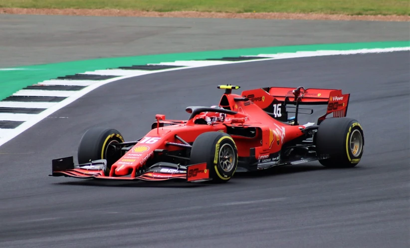 a red race car driving on a race track, a picture, by Teresa Fasolino, pexels, f 1 driver charles leclerc, london, halo, aerodynamic body