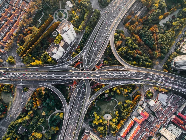 an aerial view of an intersection in a city, by Micha Klein, pexels contest winner, realism, soaring towers and bridges, highways, abundant detail, interesting background