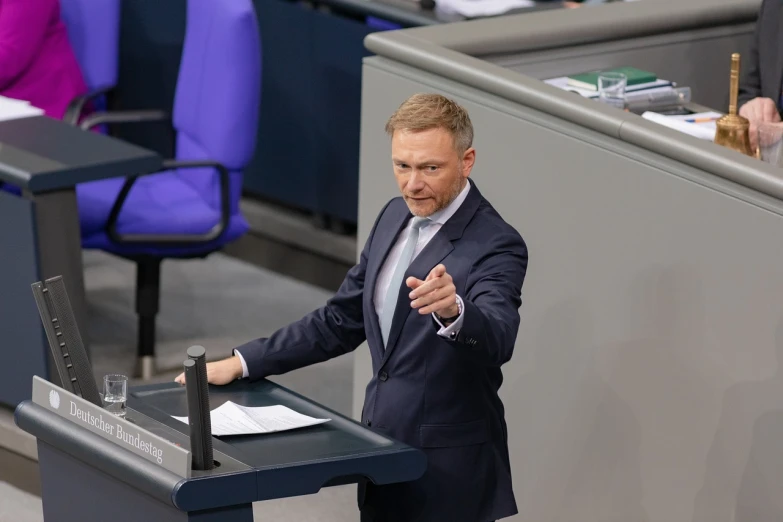 a man in a suit giving a speech, a picture, antipodeans, limmy, official photo, geiger, photo taken in 2 0 2 0