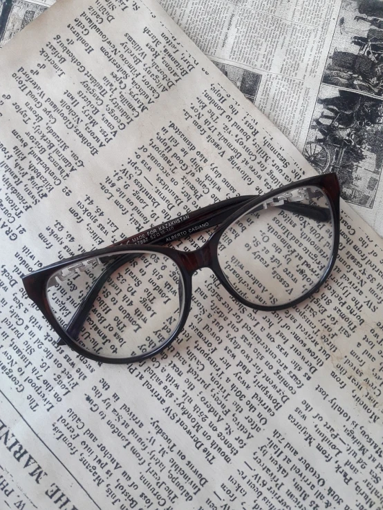 a pair of glasses sitting on top of a newspaper, by Robin Guthrie, tumblr, harry potter style, seen from straight above, vintage inspired, spoiler