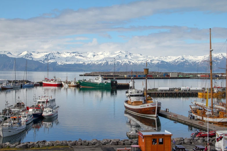 a number of boats in a body of water with mountains in the background, by Hallsteinn Sigurðsson, shutterstock, city docks, snow, tourist photo, ship