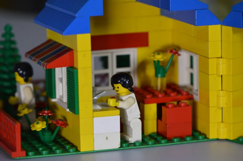 a close up of a building made out of legos, a picture, flickr, house kitchen on a sunny day, woman, computer, cottage