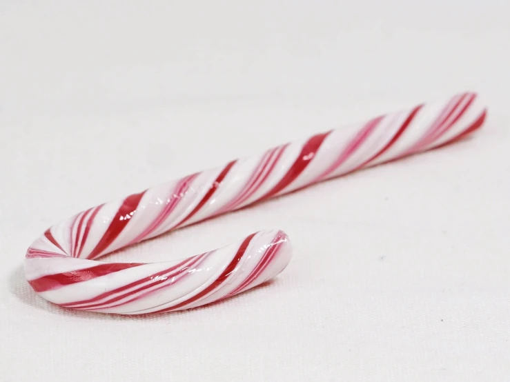 two candy canes sitting next to each other on a table, b - roll, h 1088, glazed, on the white background