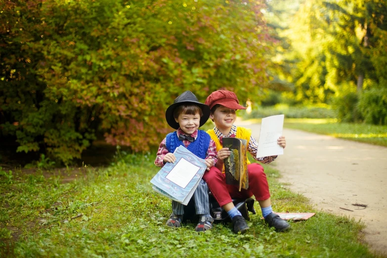 a couple of kids sitting on top of a lush green field, a picture, by Maksimilijan Vanka, holding spell book, on the sidewalk, cute boys, recital