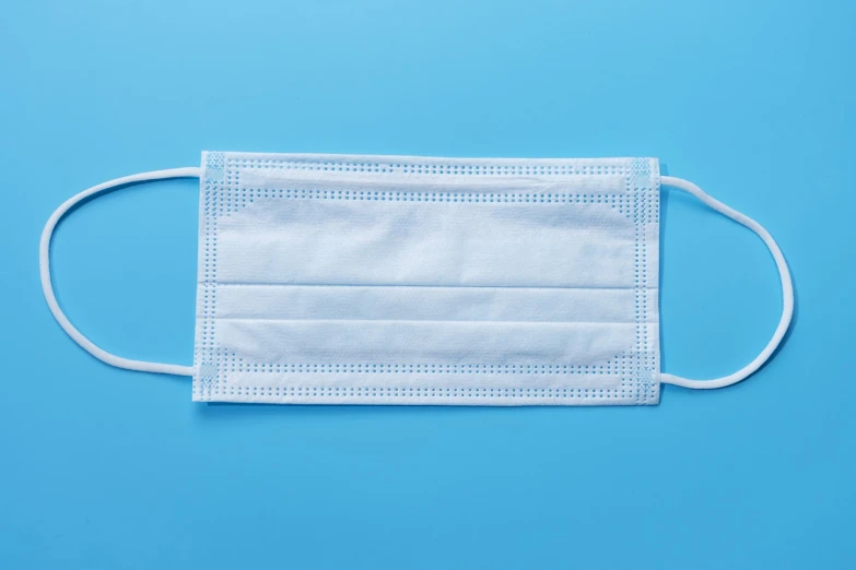 a white face mask on a blue background, a stock photo, by Julian Allen, shutterstock, with two front pockets, medical supplies, top angle view, rectangular