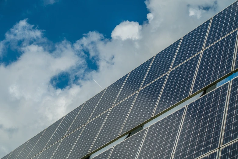 a close up of a building with solar panels on it, a stock photo, by Erwin Bowien, shutterstock, dynamic low angle shot, 4k high res, viewed from a distance, white panels