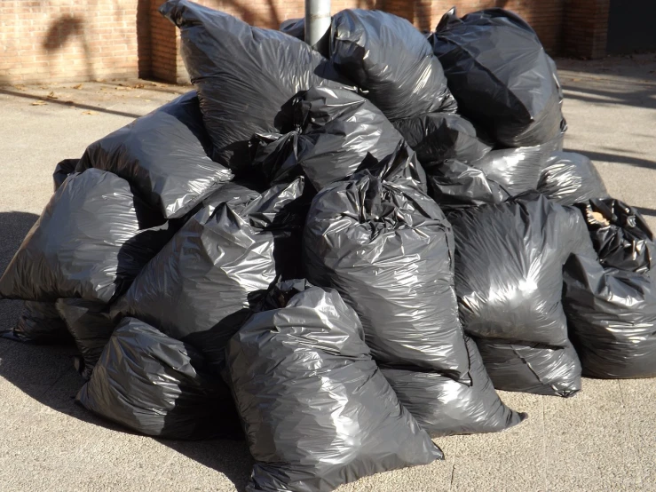 a pile of black bags sitting on top of a sidewalk, a photo, by Ramón Silva, shutterstock, plasticien, ( ( ( ( ( garbage truck, tribbles, madrid, imgur