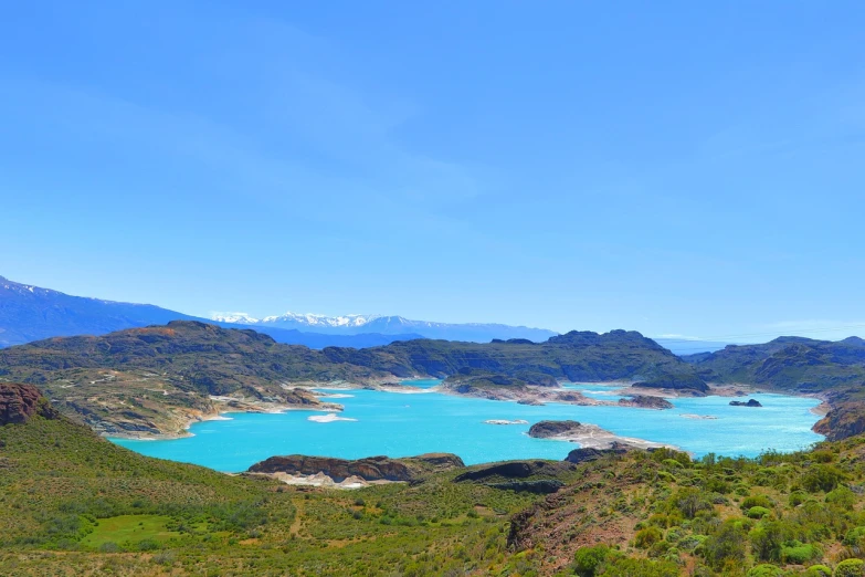 a large body of water sitting on top of a lush green hillside, by Enguerrand Quarton, shutterstock, hurufiyya, blue glacier, in chuquicamata, panoramic view, !!natural beauty!!