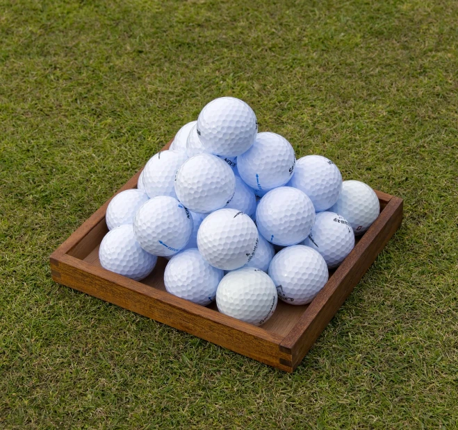 a pile of golf balls sitting on top of a wooden tray, a stock photo, precisionism, packshot, set photo