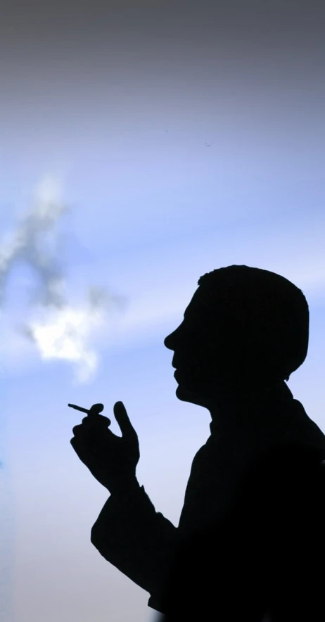 a silhouette of a man smoking a cigarette, a portrait, inspired by Rene Magritte, flickr, blue skies, photograph credit: ap, stockphoto, jets