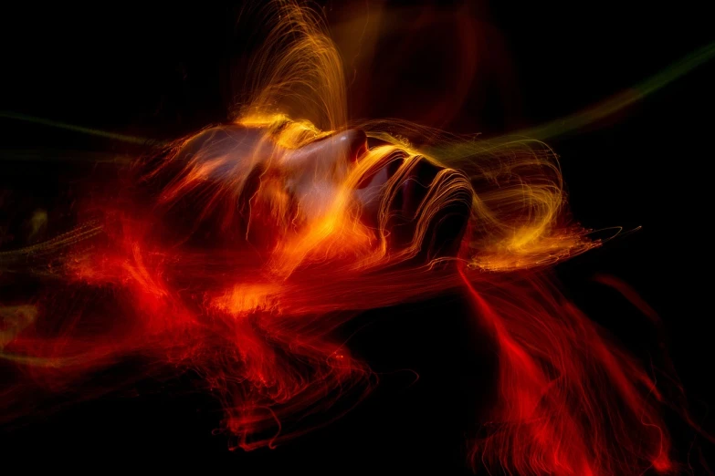 a close up of a person holding a cell phone, by Jan Rustem, digital art, hair made of fire, lying on an abstract, long exposure shot, flying scarlet phoenix