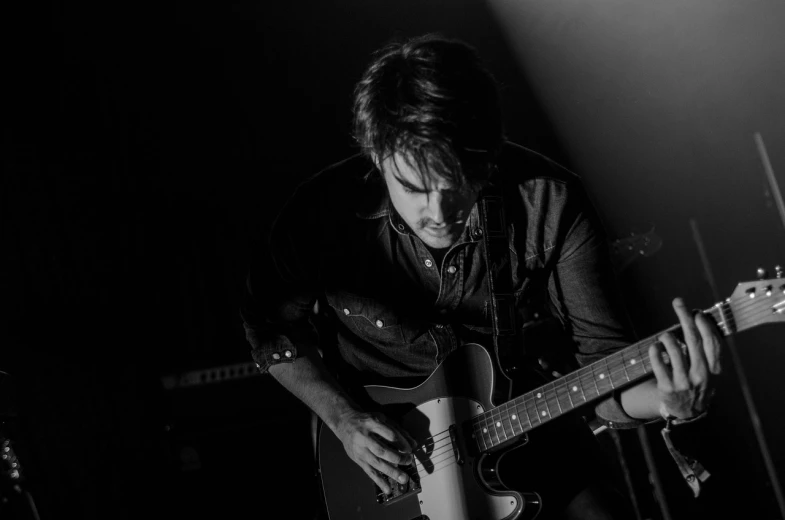 a black and white photo of a man playing a guitar, liam brazier, tom burke, high quality wallpaper, stage photography