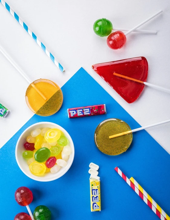 a bowl filled with assorted candies and lollipops, inspired by Albert Joseph Pénot, close-up product photo, juice, primary colors, jelly glow