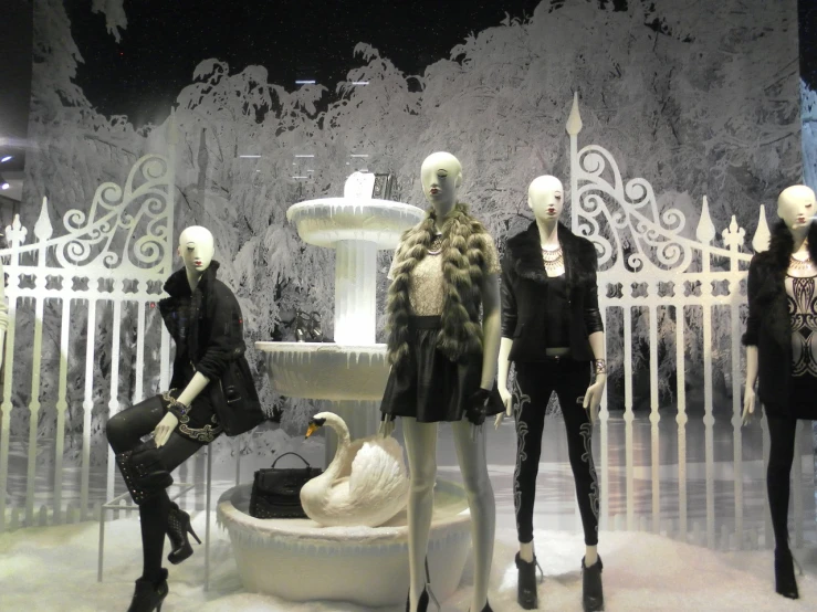 a group of mannequins standing in front of a fountain, inspired by Adam Saks, winter scene fantasy, white and black color palette, shopwindows, zaun