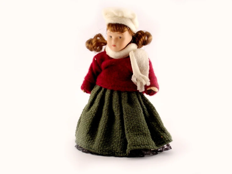 a doll wearing a red sweater and green skirt, inspired by Kate Greenaway, figuration libre, high resolution product photo, 1948, freezing, miniature product photo