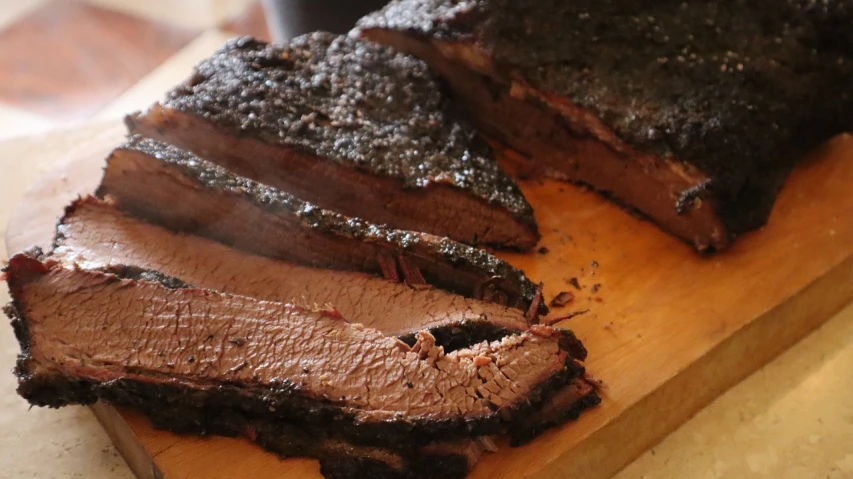 a piece of meat sitting on top of a wooden cutting board, by Robbie Trevino, gunpowder smoke, photograph credit: ap, texas, carved