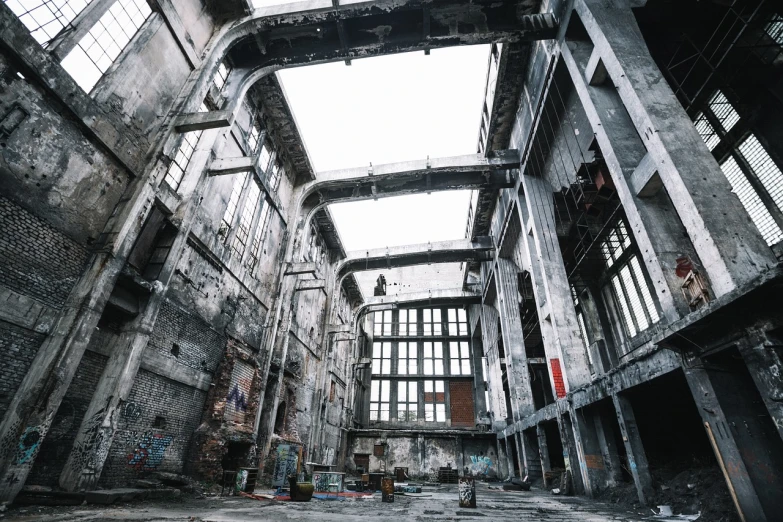 a large building with lots of windows and graffiti all over it, by Oskar Lüthy, pexels contest winner, bleak apocalyptic environment, cavernous interior wide shot, stock photo, mechanical structure