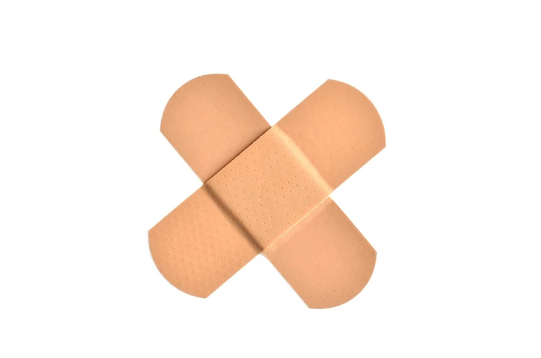 a close up of a band aid on a white surface, crosses, close-up product photo