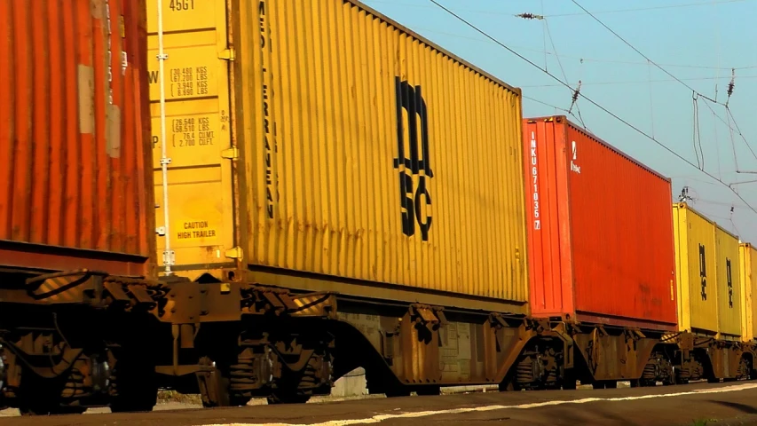 a large long train on a steel track, a portrait, flickr, shipping containers, ultrafine detail ”, c. r. stecyk iii, mustard