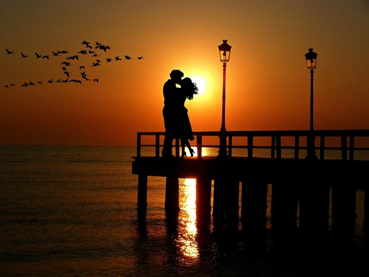a couple kissing on a pier at sunset, a picture, ((sunset)), amber, world, amazingly composed image