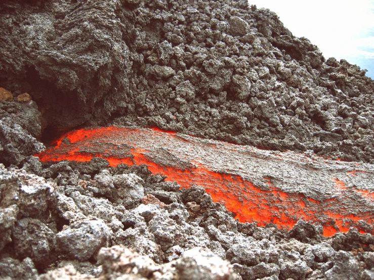 an orange substance is spewing out of the ground, by Matteo Pérez, pexels, auto-destructive art, lava rock, july 2 0 1 1, grey, frida castelli