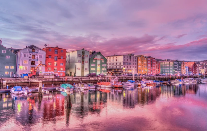 a harbor filled with lots of boats under a cloudy sky, a picture, by Johan Lundbye, shutterstock, modernism, brightly colored buildings, pink sunset, multi toned, tourist photo