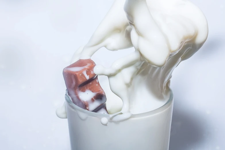 a close up of a toothbrush in a cup of milk, by Jan Kupecký, shutterstock, photorealism, fully chocolate, milk cubes, abstract claymation, pouring