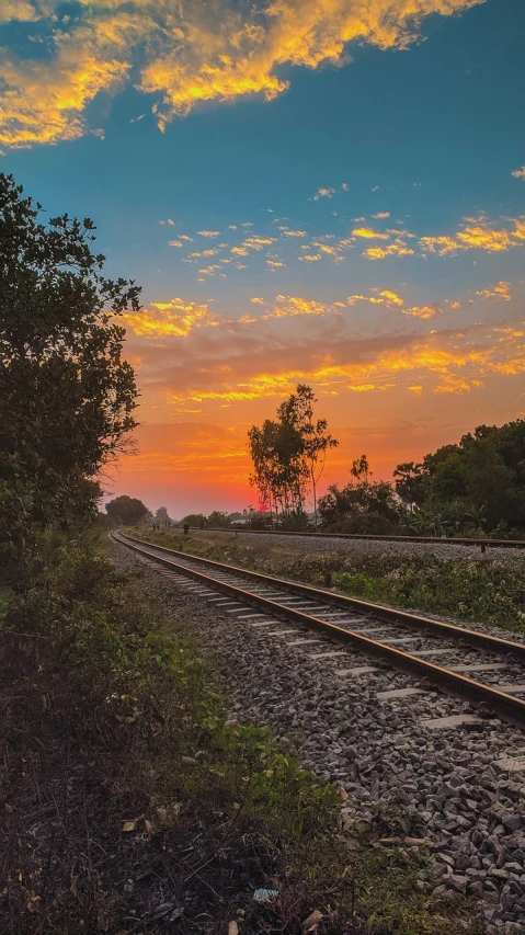 a train track with a sunset in the background, by Richard Carline, 4 0 9 6, lonely scenery yet peaceful!!, shot on nikon z9, sky on fire