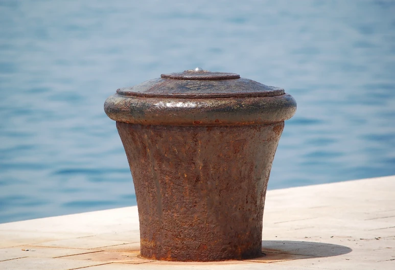 a close up of a fire hydrant near a body of water, flickr, on the deck of a sailing ship, rusted metal texture, high details photo, greek nose