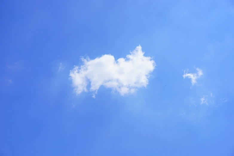 a large jetliner flying through a blue sky, a picture, inspired by Rene Magritte, minimalism, white fluffy cloud, low - angle shot, it is emitting a bright, the photo shows a large