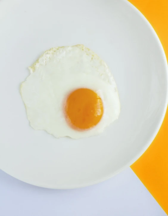 a fried egg sitting on top of a white plate, by Jan Rustem, yellow orange, close-up product photo, full image, white and yellow scheme