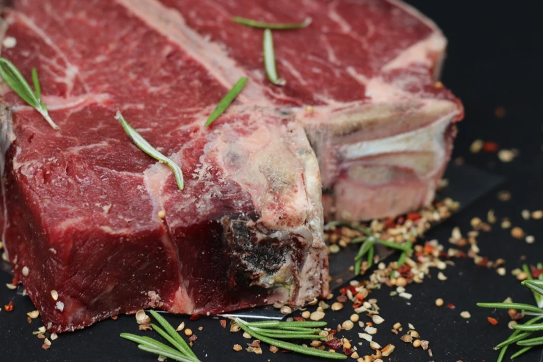 a piece of steak sitting on top of a cutting board, a picture, by Julian Hatton, pixabay, renaissance, mineral grains, side view close up of a gaunt, chiseled jaw, food particles