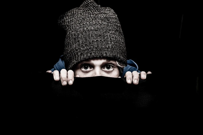 a person with a hat covering their face, a portrait, scary eyes, sneaking, wearing beanie, dark!