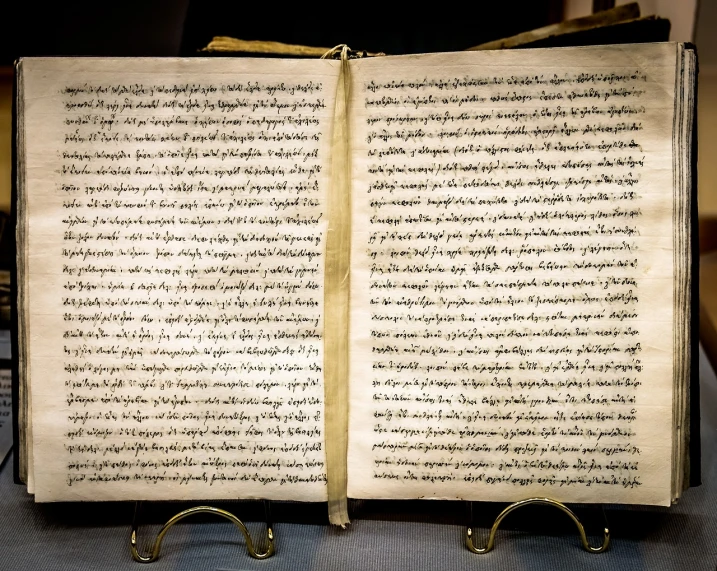 an open book sitting on top of a table, hurufiyya, museum quality photo, old script, shot in wide angle, by joseph binder