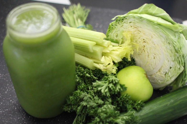 a bottle of green juice next to a bunch of vegetables, a picture, by Matt Stewart, the anatomy of a head of lettuce, soft blues and greens, photo 85mm, green and yellow colors