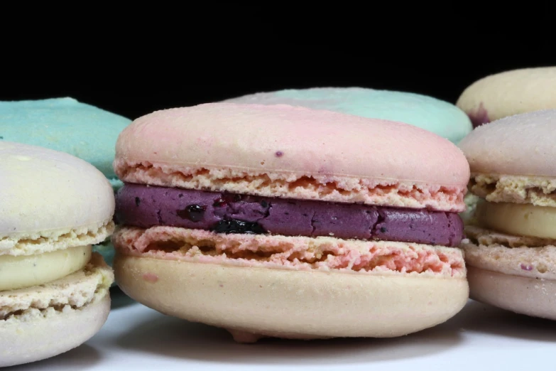 a row of macarons sitting on top of a table, a pastel, inspired by François Louis Thomas Francia, baroque, blueberry, closeup - view, 3 4 5 3 1, glaze