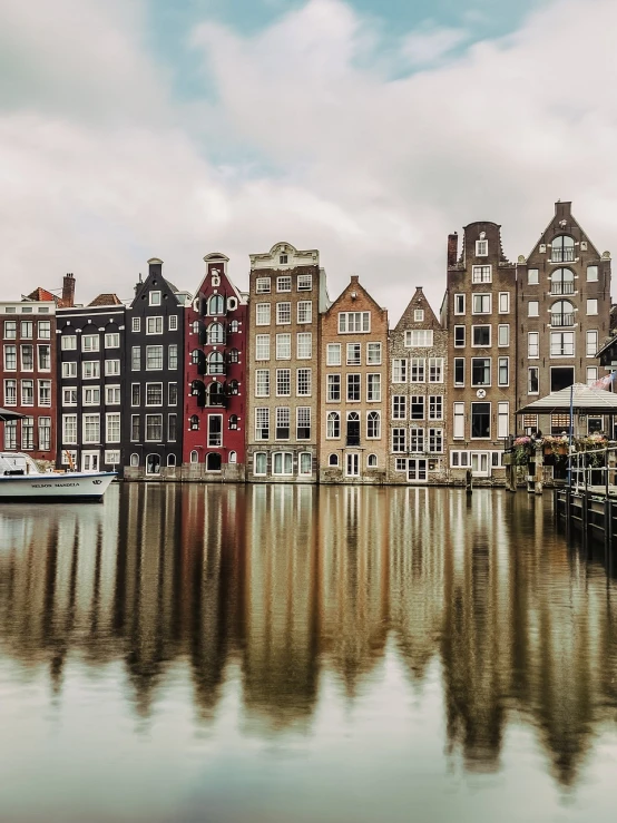 a row of buildings next to a body of water, by Jacob Koninck, pexels, art nouveau, dutch masters, on a cloudy day, best on adobe stock, tourist photo