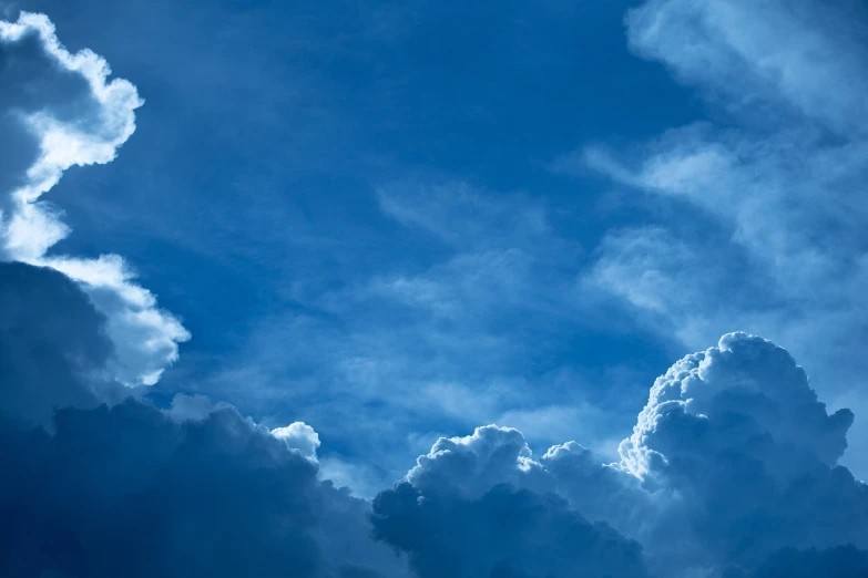 a plane flying through a cloudy blue sky, inspired by Jan Rustem, shutterstock, romanticism, moonlit clouds background, beautiful cloudy deep blue sky, ceremonial clouds, background image