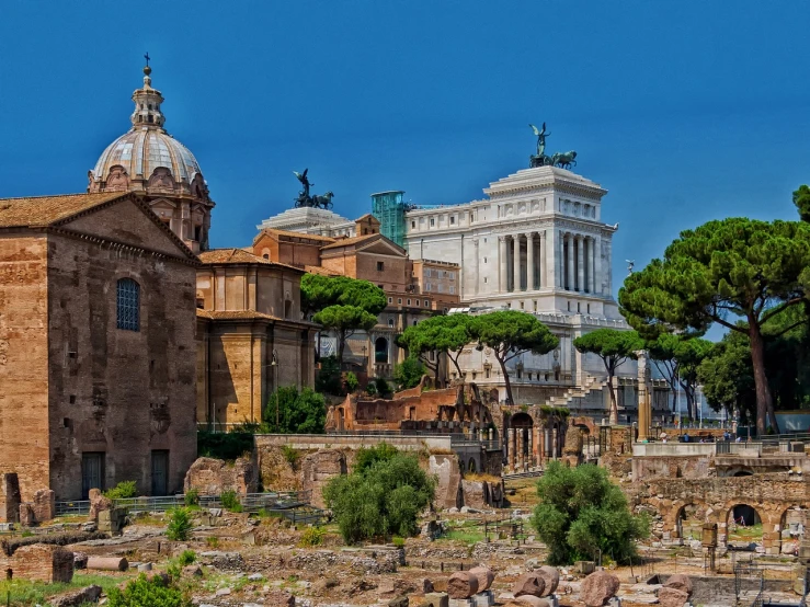 a group of buildings sitting on top of a lush green field, by Pogus Caesar, shutterstock, neoclassicism, ruined city in the background, roma, elaborate composition, preserved historical