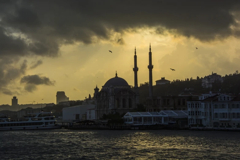 a large building sitting next to a body of water, a picture, by Nadim Karam, shutterstock, hurufiyya, overcast dawn, empire silhouette, port, sultan