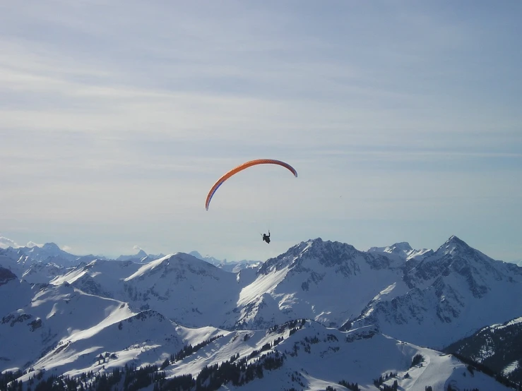 a person flying a kite on top of a snow covered mountain, a picture, by Werner Andermatt, flickr, parachutes, dingy, horizon forbideen west, amber