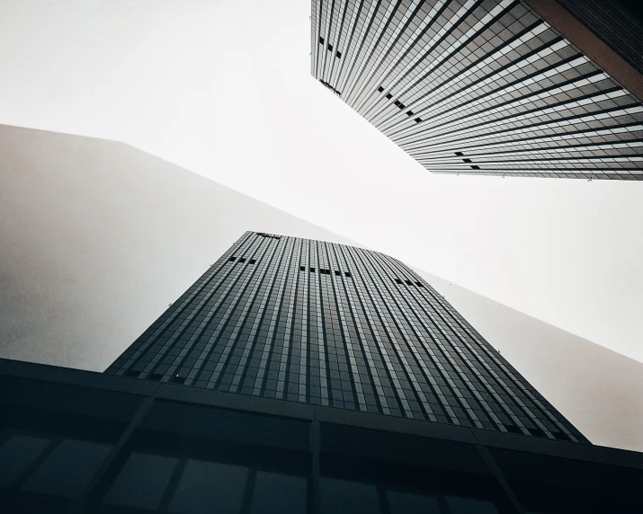 a couple of tall buildings next to each other, minimalism, looking upwards, mysterious exterior, sharp edges and focus, tall entry